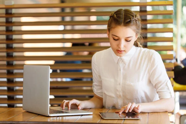 Красива молода дівчина зайнята роботою над своїм ноутбуком — стокове фото