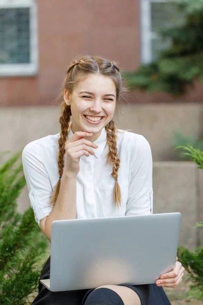 Gelukkig jong meisje werkt op laptop in park — Stockfoto