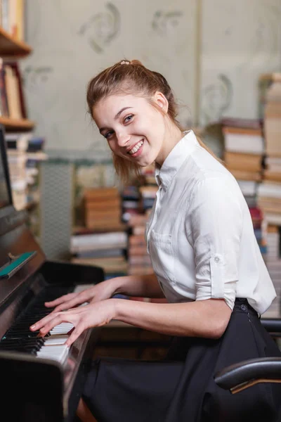 Mujer joven con una blusa blanca tocando el piano —  Fotos de Stock