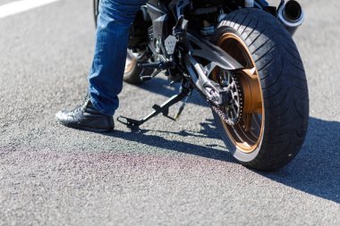 Bir motosiklet bir close-up yalnız sahibi olan yol üzerinde duruyor