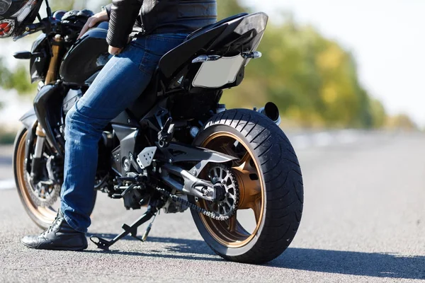 Um close-up de uma motocicleta fica na estrada com seu proprietário sozinho — Fotografia de Stock