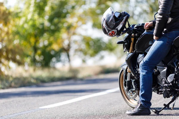 Um close-up de uma motocicleta fica na estrada com seu proprietário sozinho — Fotografia de Stock