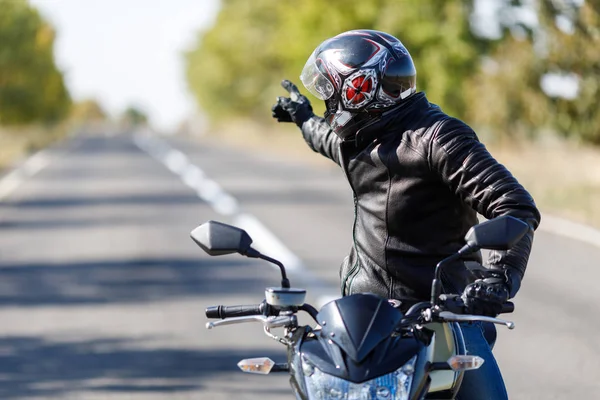 Un primer plano de una motocicleta se encuentra en la carretera con su propietario solo — Foto de Stock