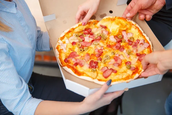 The ordered pizza in a close-up box is very appetizing