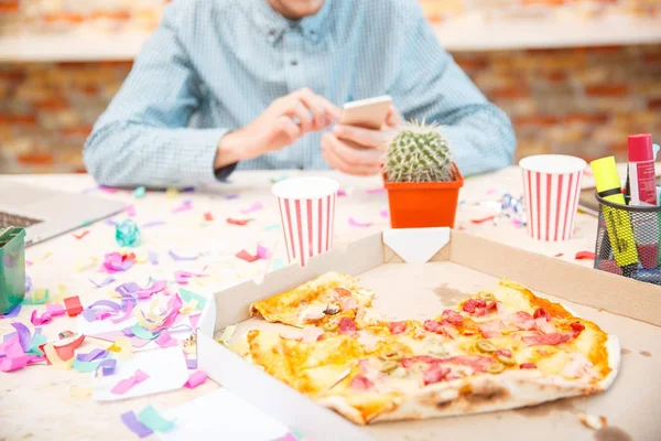 A company of young workers are browsing something on a tablet on a background of pizza closeup — Stock Photo, Image