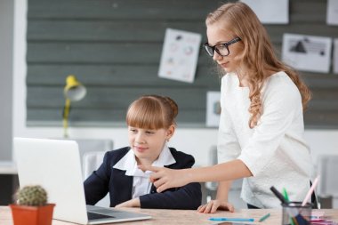 Küçük bir iş kadını bir bilgisayarda çalışıyor ve bir çalışan tarafından yardımcı oldu