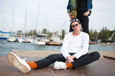 Yakışıklı çocuk ananas açık havada doğa zemin üzerine oturuyor.