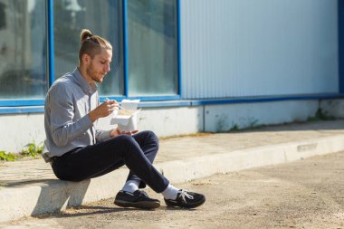 Çin eriştesi kutusunda karides, sebze ve Soya soslu susam ile yakışıklı adam. Gıda kavramı.