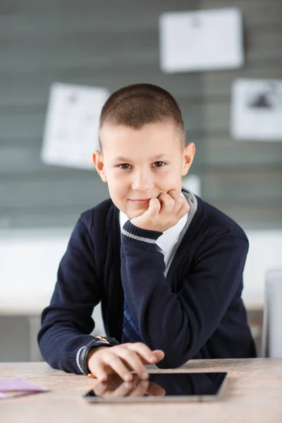 Un petit homme d'affaires est assis sur le lieu de travail avec une tablette sur la table — Photo