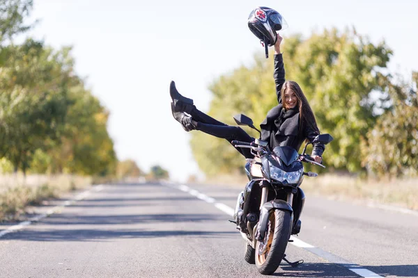 Siyah deri giysiler içinde bir motosiklet üzerinde bir kız oturuyor — Stok fotoğraf