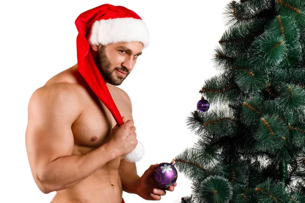 Сексуальный рождественский мужчина, стоящий рядом с ёлкой на белом фоне . — стоковое фото
