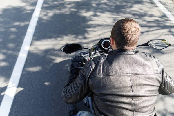 Motociclista sentado em uma moto close-up vista por trás — Fotografia de Stock