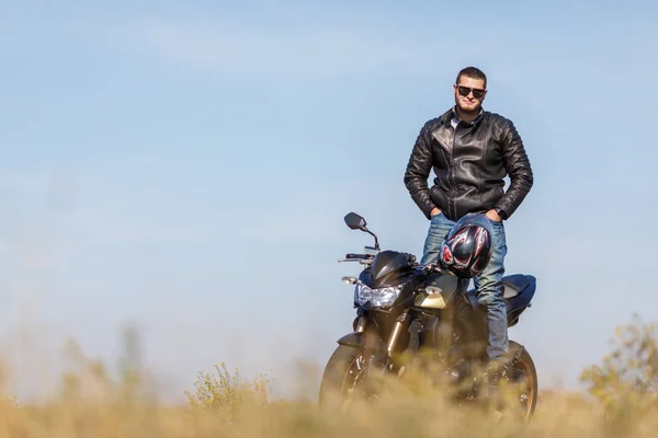 Красивый мотоцикл стоит на дороге в одиночестве со своим владельцем — стоковое фото