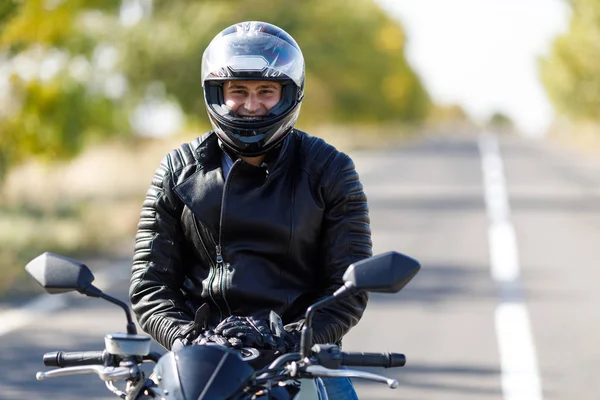 Een close-up van een motorfiets staat op de weg met zijn eigenaar alleen — Stockfoto