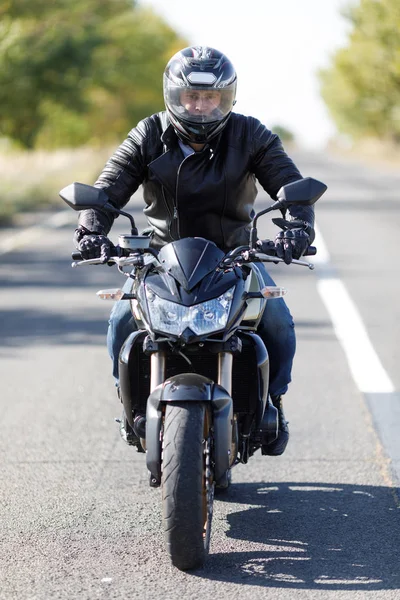 Um close-up de uma motocicleta fica na estrada com seu proprietário sozinho — Fotografia de Stock