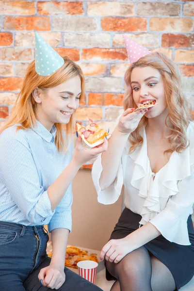 Dos chicas comen pizza en una oficina —  Fotos de Stock