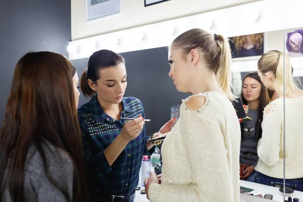 Vizážista klade na make-up na plochu modelu a dívka — Stock fotografie