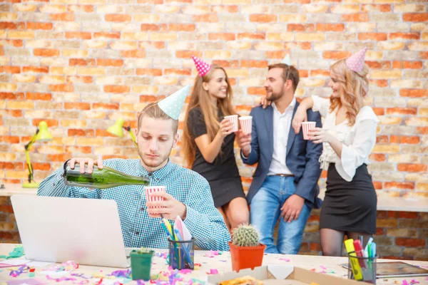 Der Mitarbeiter arbeitet für einen Laptop vor dem Hintergrund der Feierlichkeiten des Ferienunternehmens — Stockfoto