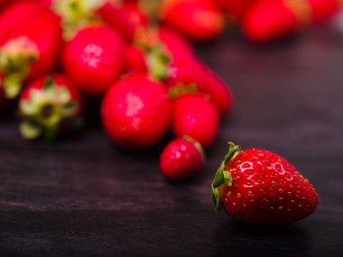 Koyu ahşap bir masa üzerinde tatlı taze çilek. Gıda kavramı.