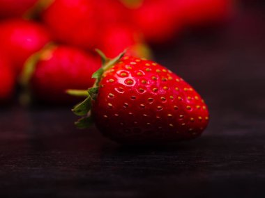 Koyu ahşap bir masa üzerinde tatlı taze çilek. Gıda kavramı.