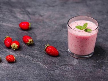 Gri bir arka plan üzerine bir bardak tatlı taze çilek jogurt. Gıda kavramı.