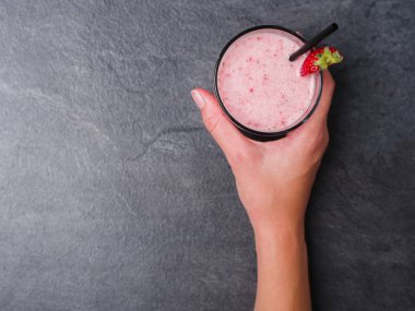 Tatlı taze çilek jogurt gri mermer zemin üzerine bir bardak. Gıda kavramı.