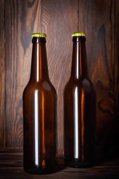 Bouteilles avec bière sur fond de bois brun — Photo