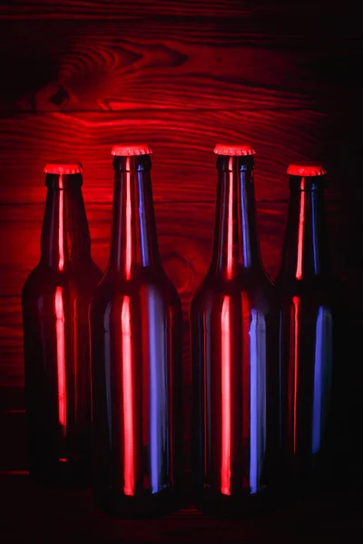 Garrafas com cerveja em um fundo de madeira marrom — Fotografia de Stock
