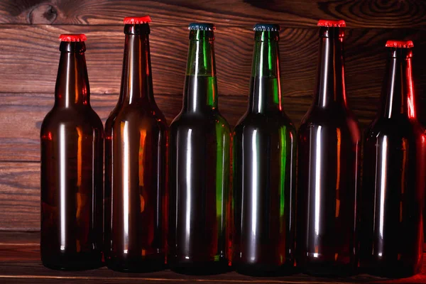 Бутылки с пивом на коричневом фоне — стоковое фото