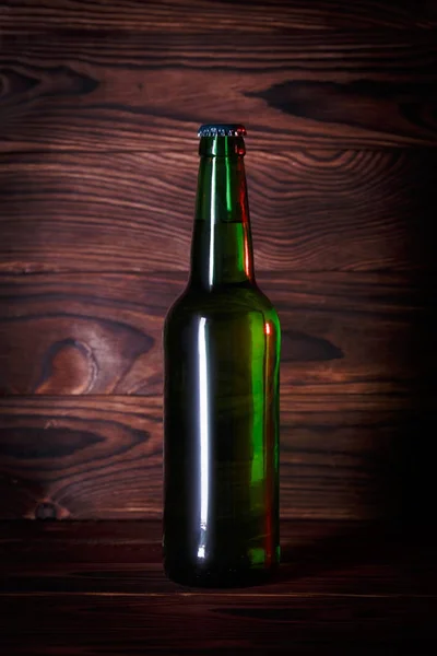 Bouteille avec bière sur fond de bois brun — Photo