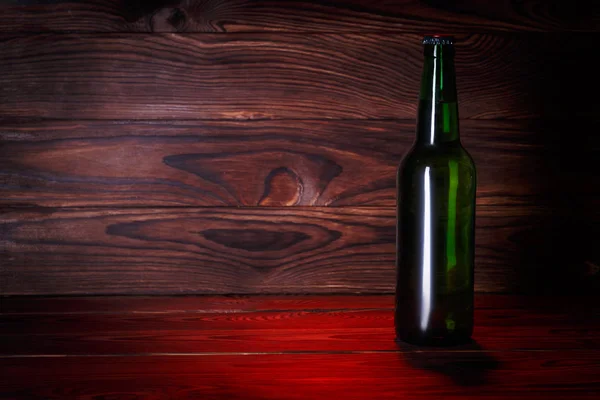 Garrafas com cerveja em um fundo de madeira marrom — Fotografia de Stock