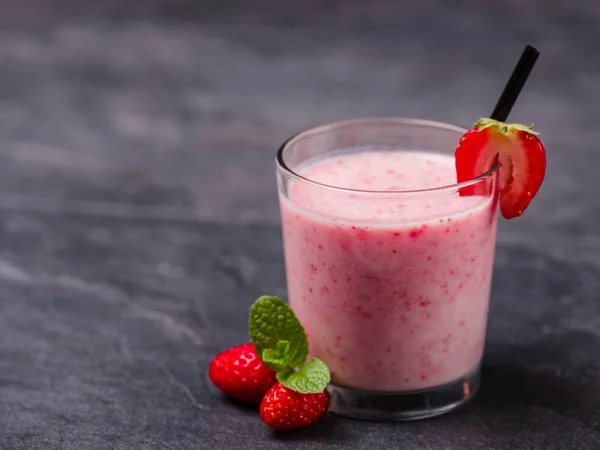 Des fraises fraîches sucrées jogurent dans un verre sur fond gris. Concept alimentaire . — Photo