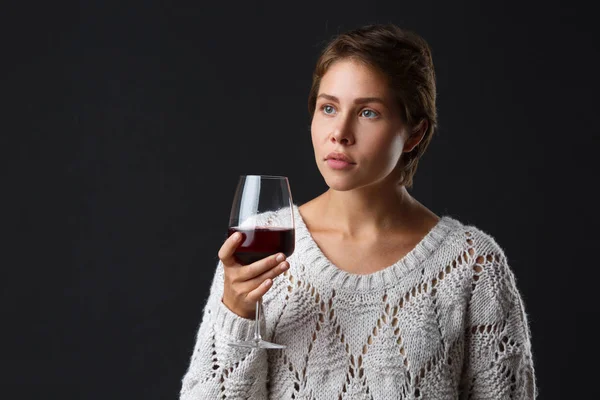 Красивая девушка с бокалом красного вина на черном фоне . — стоковое фото