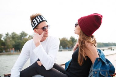 Kız adamla suyun kenarında oturuyor