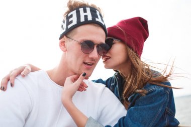 Kız adamla suyun kenarında oturuyor