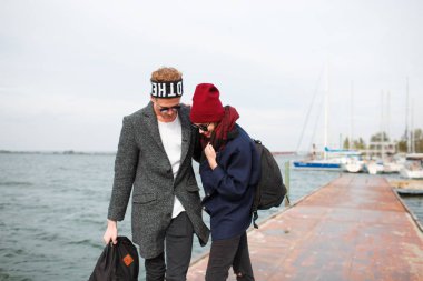 Pier girl on kız adamla kaykay üzerinde sürme