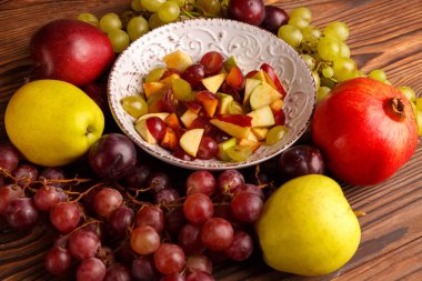 Lezzetli salata meyve ahşap bir masa üzerinde bir tabak içinde.