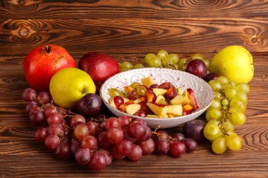 Lezzetli salata meyve ahşap bir masa üzerinde bir tabak içinde.