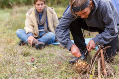 İki ormanın içinde. Bir adam bir yangın çıra.