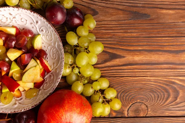 Lezzetli salata meyve ahşap bir masa üzerinde bir tabak içinde.