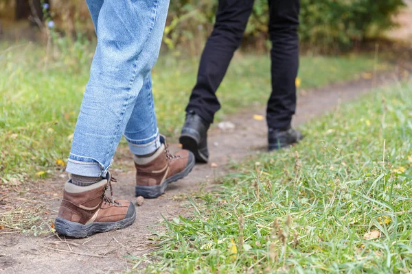 Las piernas de una chica y un hombre en el bosque — Foto de Stock