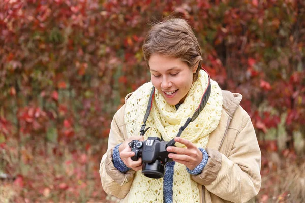 Genç bir kız, bir sonbahar ormanındaki bir kamera ile. — Stok fotoğraf