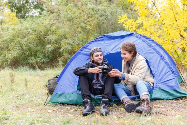 Ein junges Touristenpaar im Wald beim Betrachten von Fotos mit der Kamera. — Stockfoto