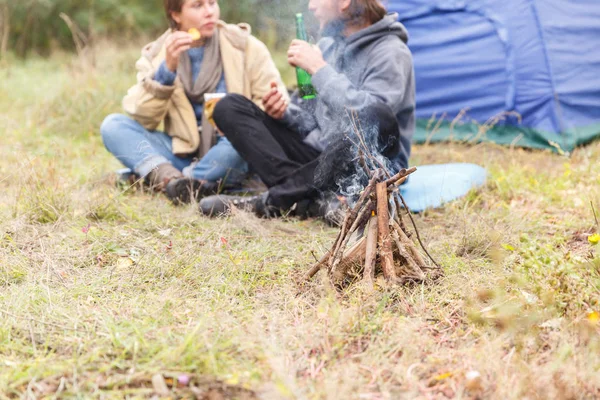 Couple relaxing in the forest. A loving couple is sitting in front of the tent.