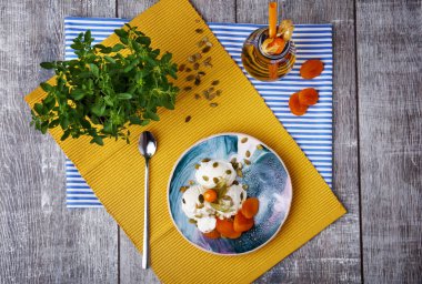 Soğuk dondurma tohumları, Kuru Kayısı, dekoratif yaprakları ve bir şişe suyu ahşap masa arka plan üzerinde mavi bir kase. Sağlıklı Ürünler parlak bir dizi Üstten Görünüm. 