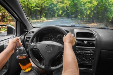 Irresponsible and violent young man driving a new, expensive car and drinking a beer in a bottle. A boozed student suffering from alcoholic intoxication driving on a car background.  clipart