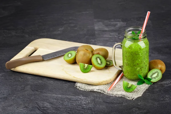 Ein Schreibtisch Mit Geschnittenen Und Ganzen Kiwis Und Einem Messer — Stockfoto