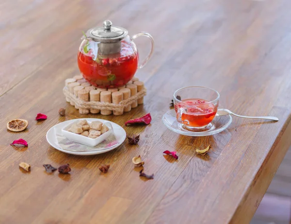 茶色の木製の背景に有機果実飲料のティーポットの組成のクローズ アップ ポット テーブルに新鮮な野生ストロベリー紅茶のカップの茶色のキューブとプレート — ストック写真