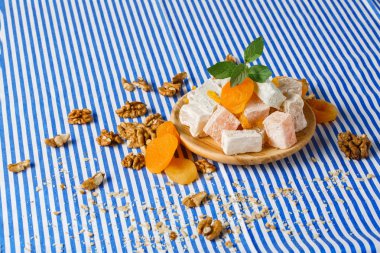 Türk Lokumu, lokum veya rahat lokum closeup, freah nane, parlak Kuru Kayısı bırakır bir ahşap plaka, ceviz, ceviz çizgili bir arka plan üzerinde masada kırıntıları.