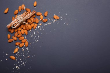 Badem, aromatik tarçın, bir bileşeni çeşitli yemekler, badem ezmesi, kurabiye, kek ve diğer tatlılar ve tatlılar bir koyu mor arka plan üzerinde olan bir sürü yer Kopyala.